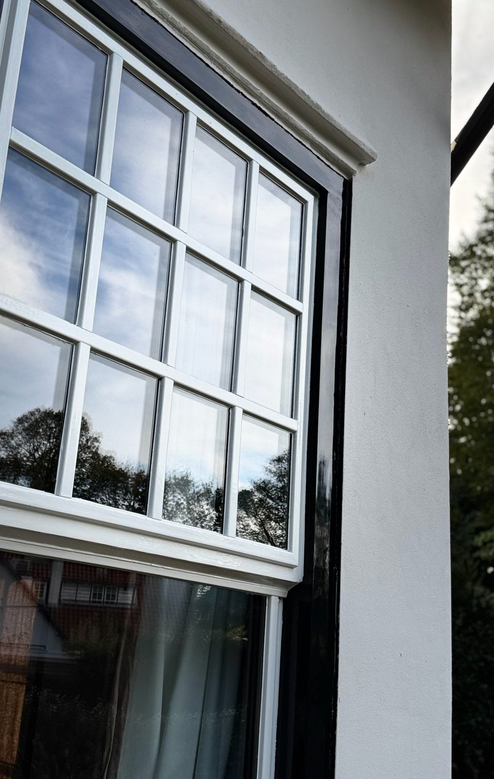 Detail kozijn met witte sponning en zwart geschilderde stijl